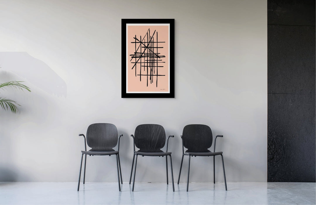Modern chairs in a room with a  pink framed abstract artwork on the wall.