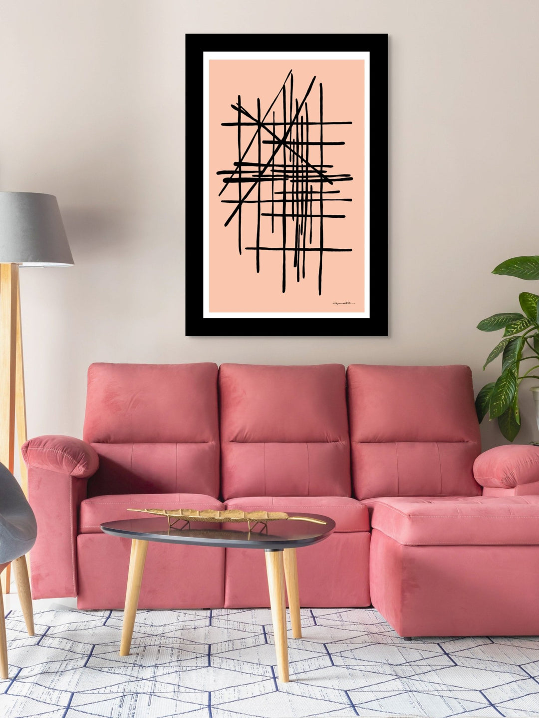 Pink sofa in a living room with a modern abstract pink art piece on the wall.