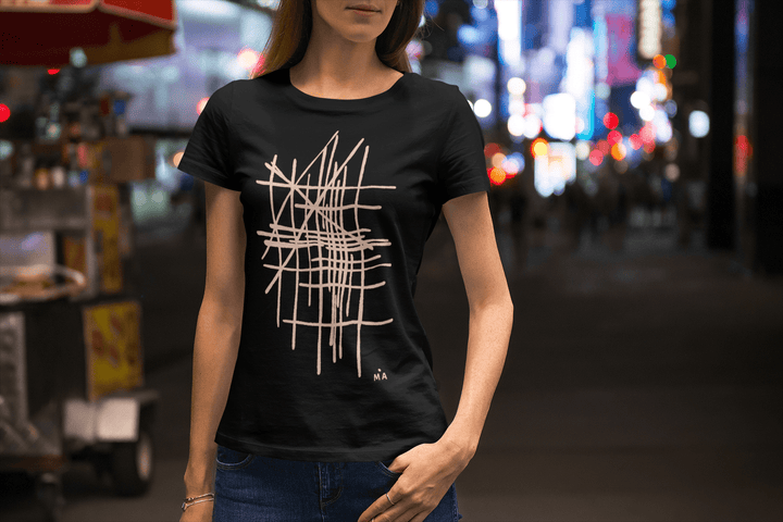 woman wearing a black t-shirt with white geometric design in an city night setting