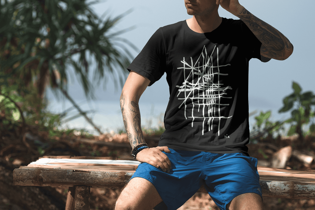 Man wearing a black t-shirt with a white abstract graphic design, sitting outdoors.