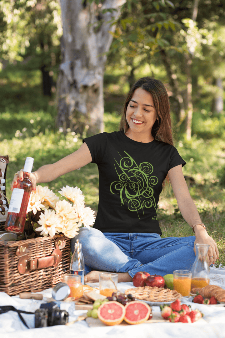 Wearing the Trend - Abstract T-Shirt by Miamiabstract.com, a woman enjoys a picnic on a blanket, smiling as she reaches for rosé wine near a wicker basket with flowers and fruits, surrounded by greenery and sunlight.