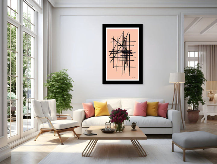 Modern living room with a white sofa, colorful pillows, and a pink framed abstract art piece on the wall.