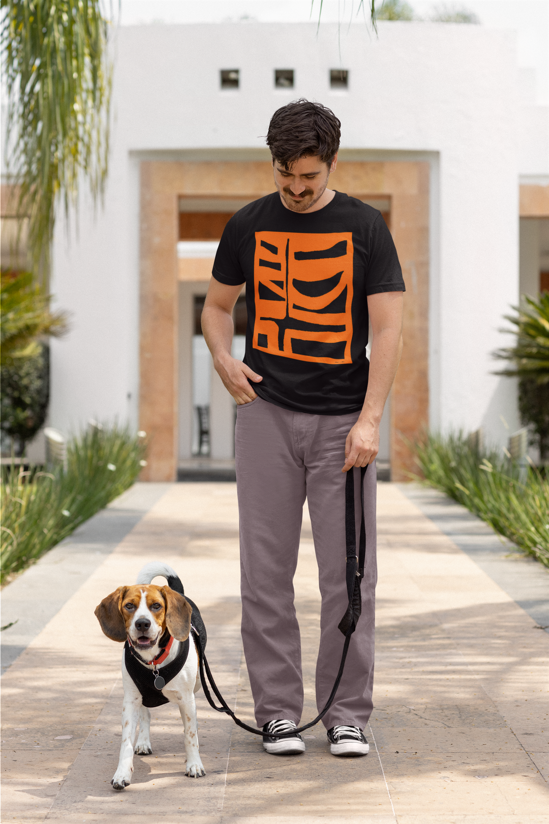 man with a mustache ready to take his dog for a walk wearing abstract t shirt BI 500 in orange
